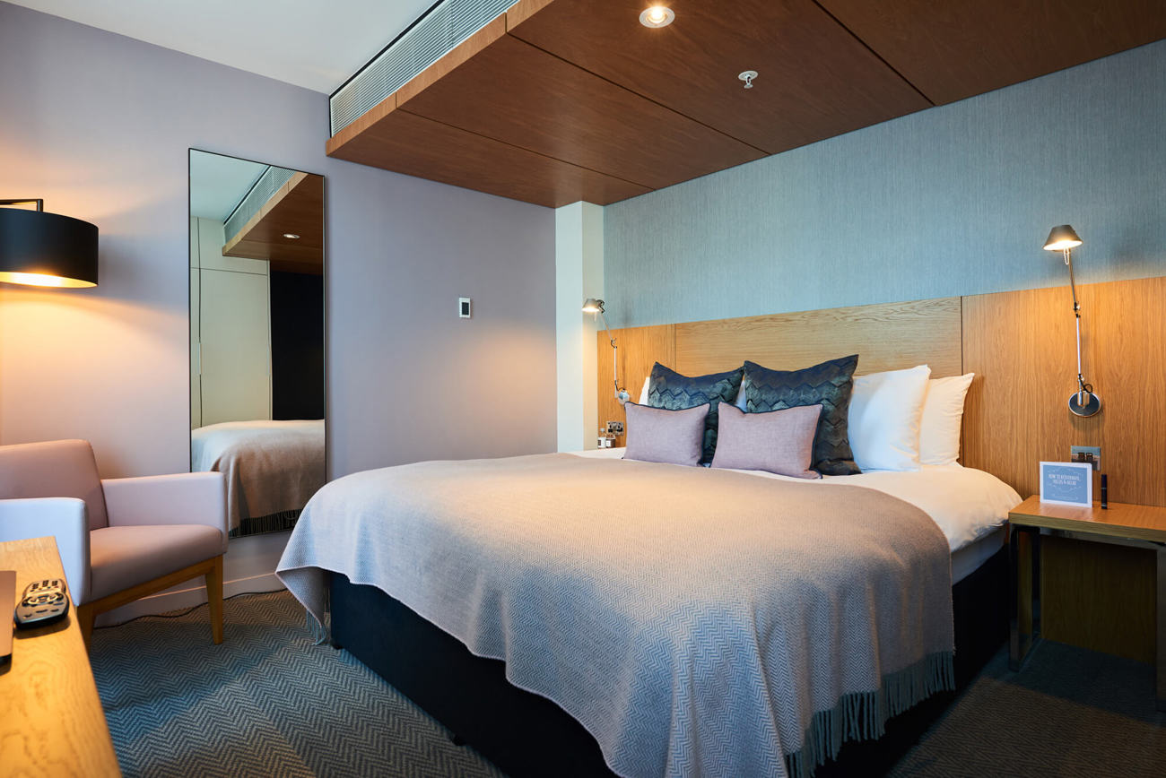 Junior Suite bedroom with king-size bed and desk area at Apex City of London Hotel