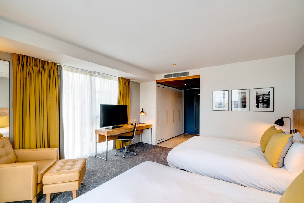 Family Room bedroom with two beds, armchair and desk