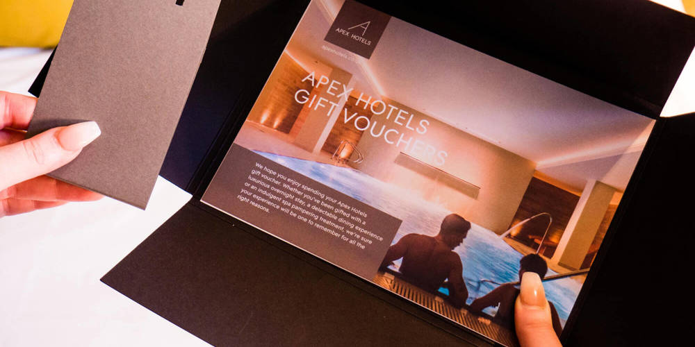 Hands holding an Apex Hotels gift voucher