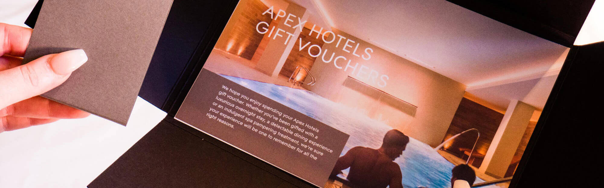Hands holding an Apex Hotels gift voucher