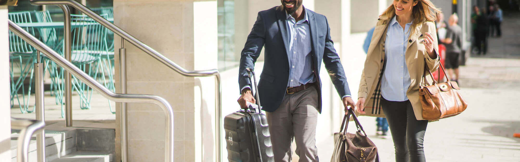 Staff member helping guest into hotel with her bags