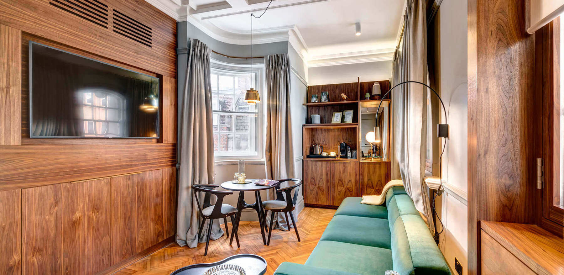 Grand Suite living area with sofa, TV and table at Apex Temple Court Hotel