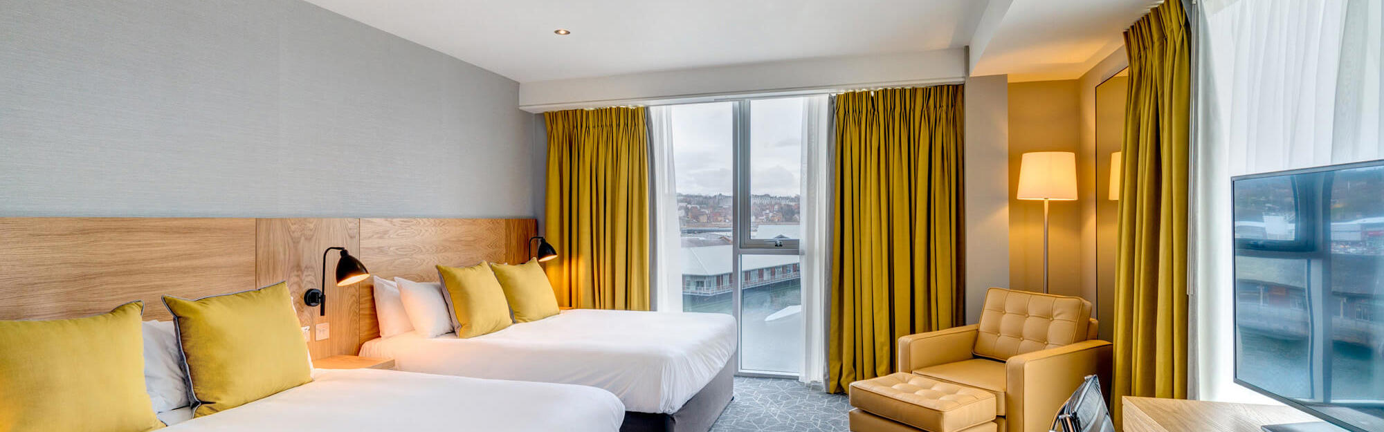 Family Room with City Quay views and two beds, desk and armchair