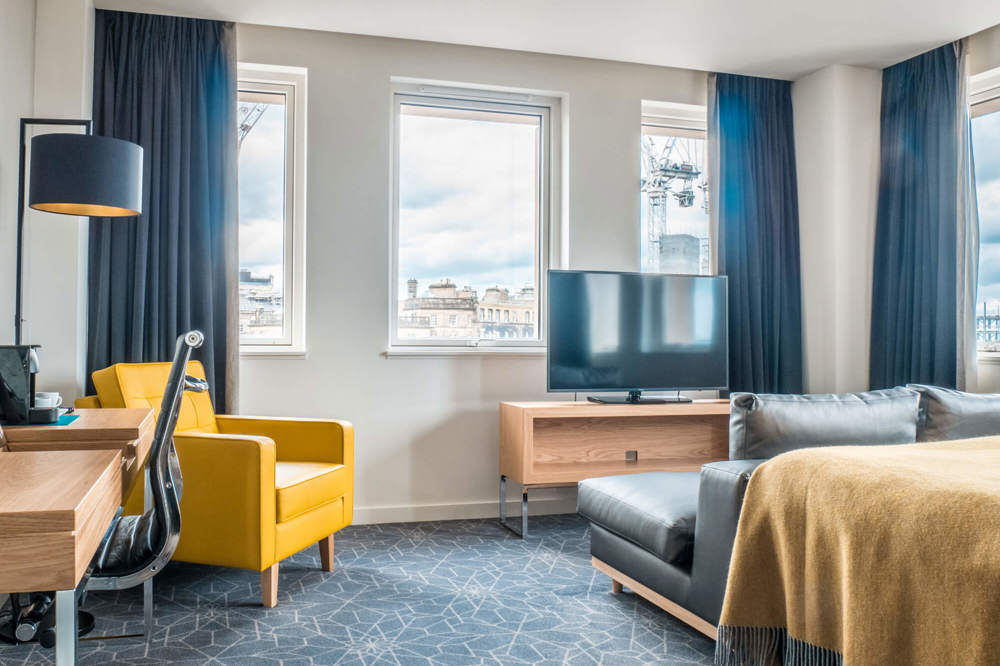 Deluxe Room with king-size bed and seating area at Apex Waterloo Place Hotel