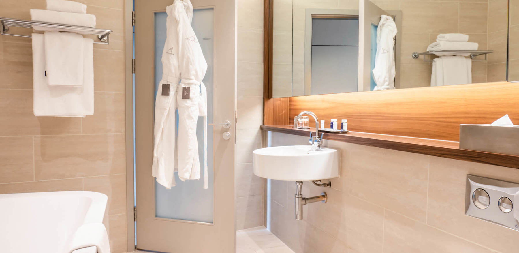 Superior Room bathroom with bath and robes hanging on the back of door at Apex Waterloo Place Hotel