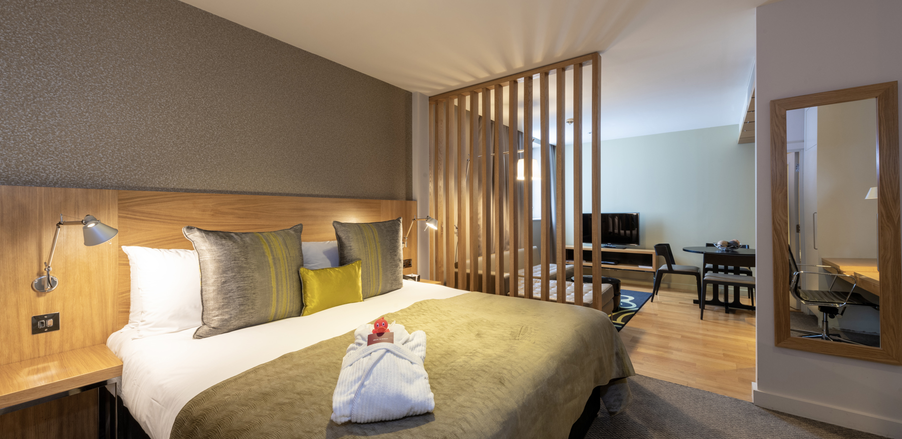 Bedroom area with bed and TV in Junior Suite at Apex Temple Court Hotel