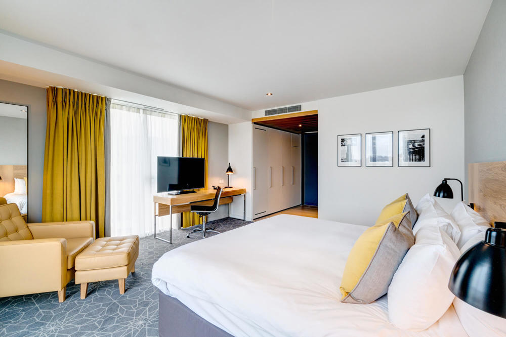 King-size bed with armchair and desk with TV