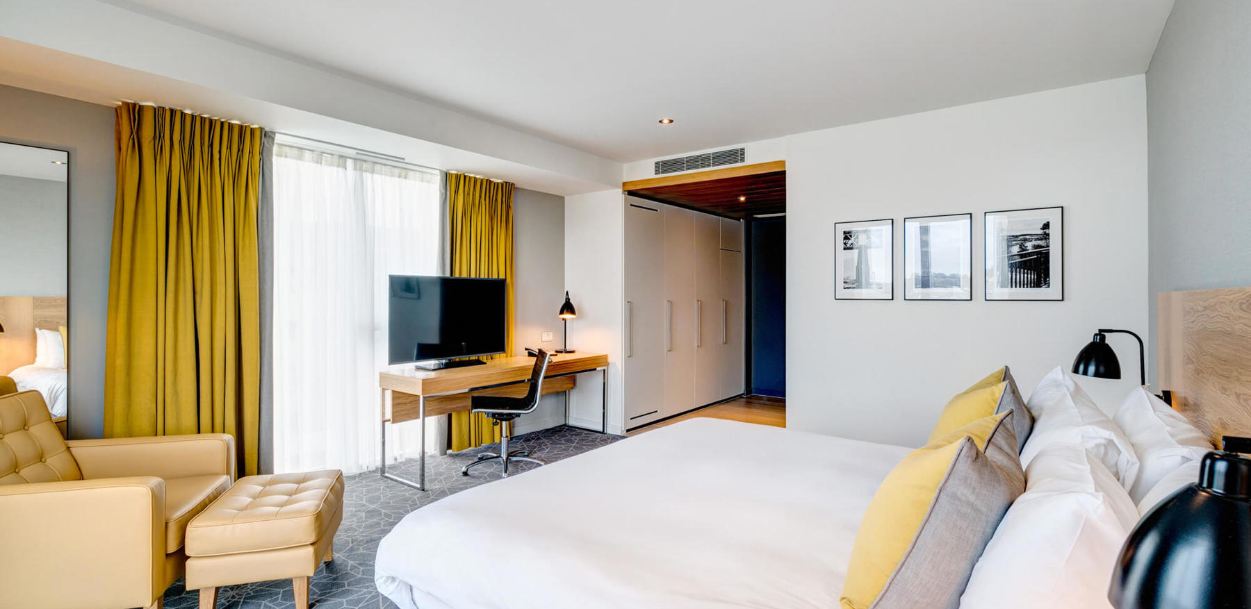 King-size bed with armchair and desk with TV