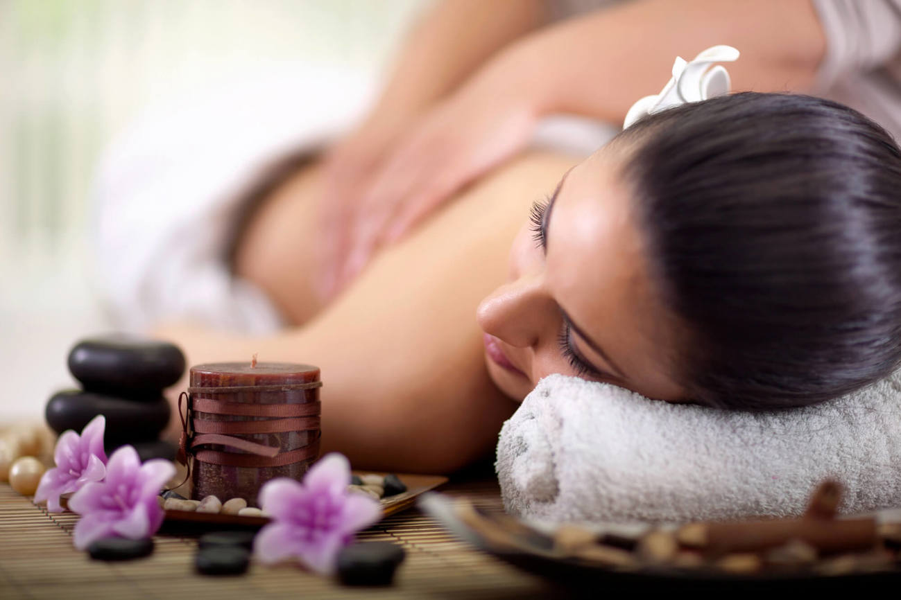 Woman getting a massage with hot stones next to her
