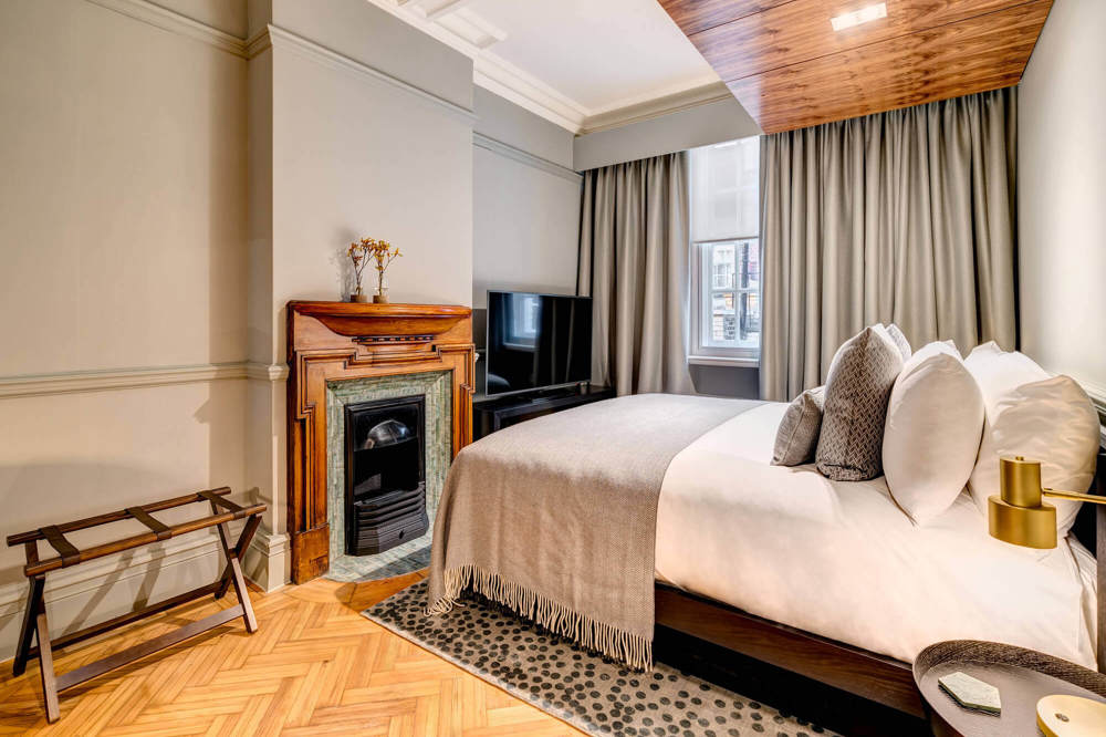 Grand Suite bedroom with fireplace at Apex Temple Court Hotel