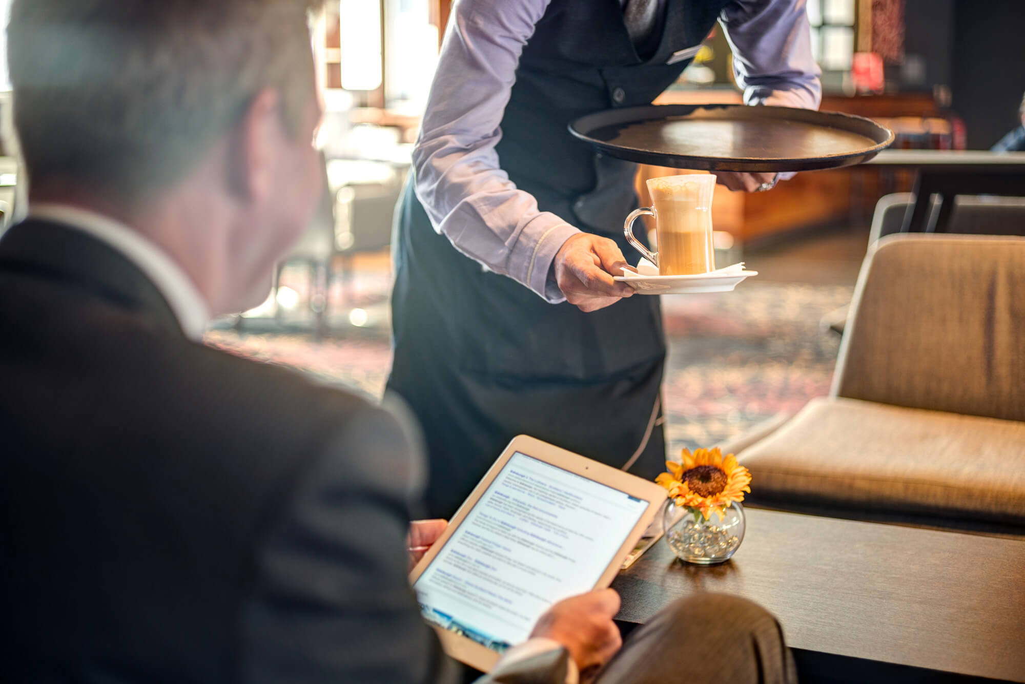 Waiter serving guest coffee